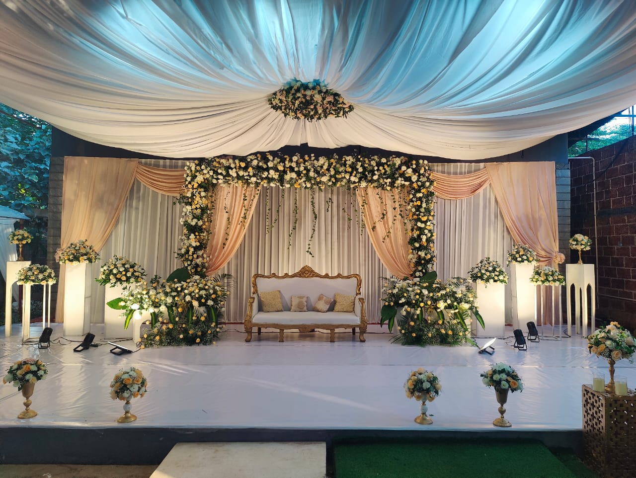Wide reception layout in Pergola ballroom with gold chairs and floral centerpieces.
