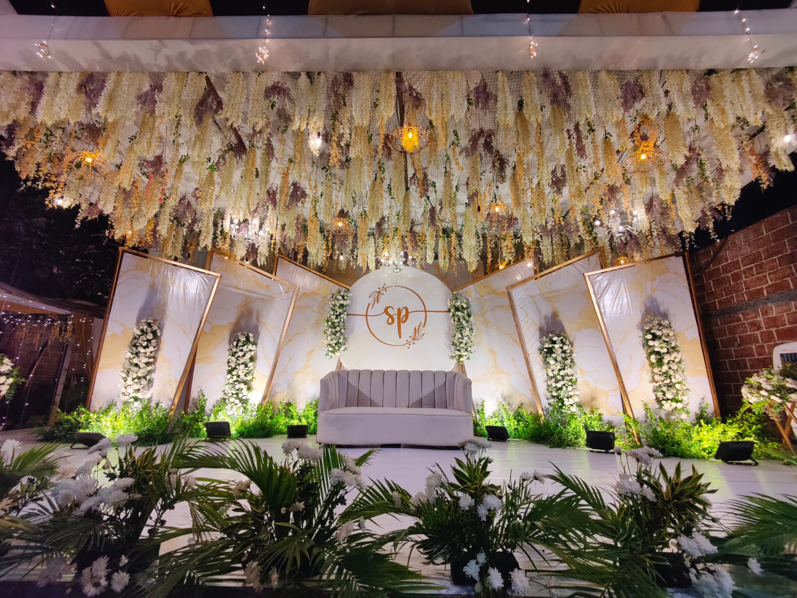 Traditional stone shrine corner with marigold garlands at Pergola.